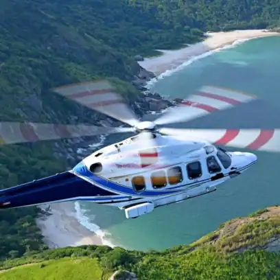 helicopter flying over mountain and beach